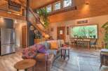 Experience rustic charm in this inviting living space, featuring a plush leather sofa adorned with colorful throws and pillows.