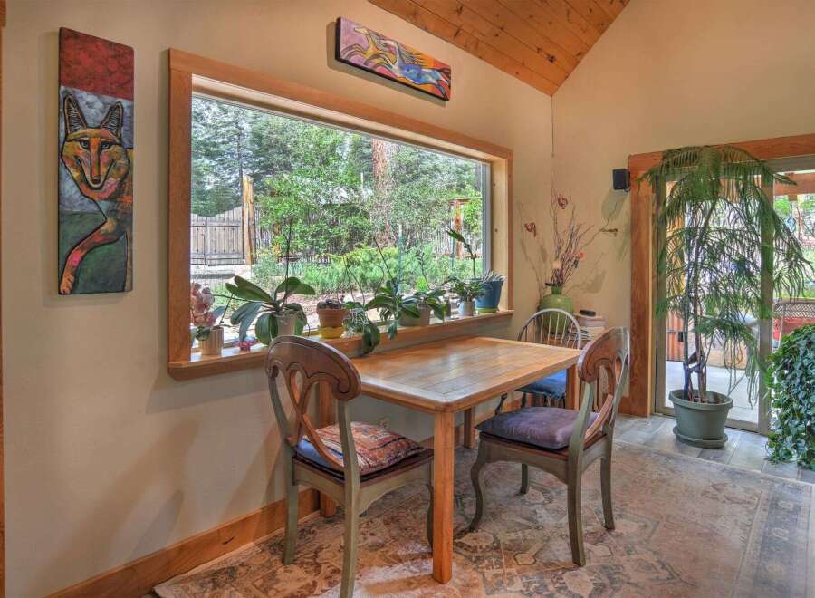 Enjoy a charming breakfast nook with a large window offering picturesque views of the lush greenery outside.