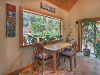 Enjoy a charming breakfast nook with a large window offering picturesque views of the lush greenery outside.