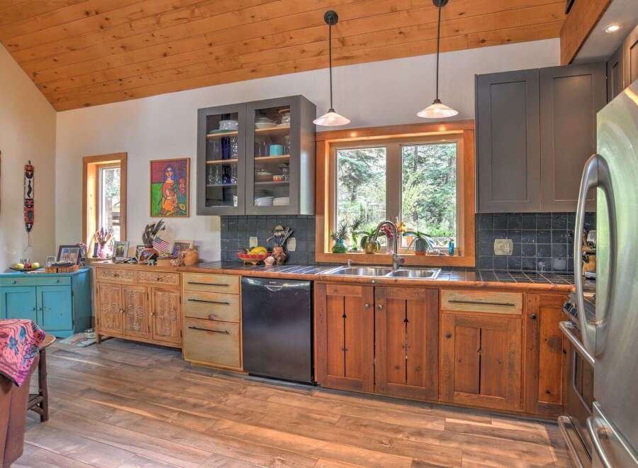 This charming kitchen boasts rustic wooden cabinetry and a beautiful wood-paneled ceiling, creating a warm and inviting atmosphere.
