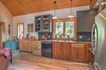 This charming kitchen boasts rustic wooden cabinetry and a beautiful wood-paneled ceiling, creating a warm and inviting atmosphere.