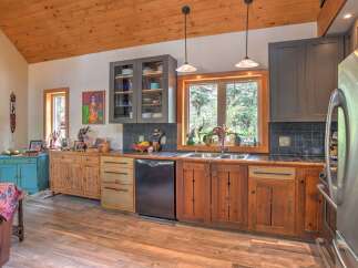 This charming kitchen boasts rustic wooden cabinetry and a beautiful wood-paneled ceiling, creating a warm and inviting atmosphere.
