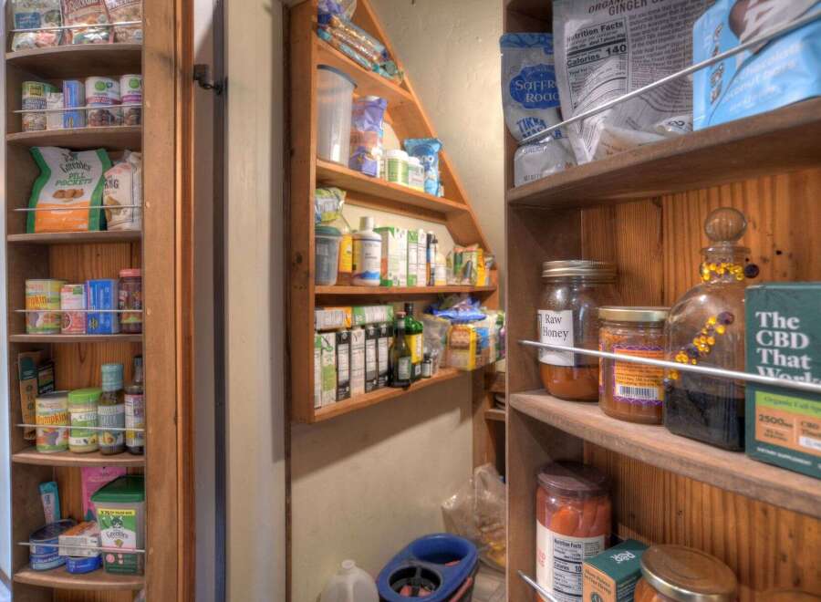 Discover a well-organized pantry, showcasing a variety of organic foods, canned goods, and health supplements.