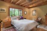 Experience serene living in this charming bedroom, featuring a cozy bed dressed in crisp white linens and accented with decorative pillows.