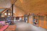 Discover this charming loft space featuring a vaulted, wood-paneled ceiling and exposed beams, creating a warm and inviting atmosphere.