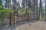Discover rustic charm with this unique wooden gate and fence, set amidst a serene forest backdrop.