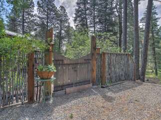 Discover rustic charm with this unique wooden gate and fence, set amidst a serene forest backdrop.
