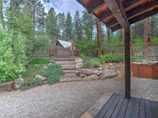 Discover this charming property featuring a rustic wooden gate leading to a serene backyard oasis.