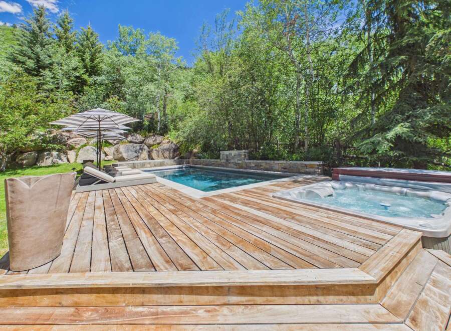 Escape to this luxurious backyard oasis featuring a sparkling swimming pool and a relaxing hot tub, perfect for unwinding.