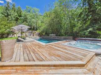 Escape to this luxurious backyard oasis featuring a sparkling swimming pool and a relaxing hot tub, perfect for unwinding.