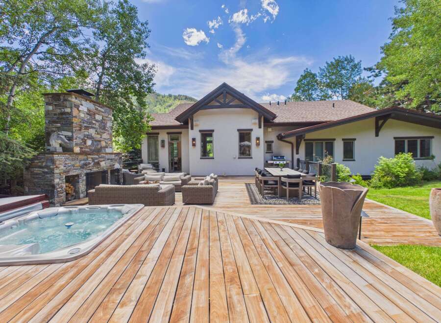 Experience luxurious outdoor living with this stunning backyard oasis, featuring a spacious wooden deck perfect for entertaining.