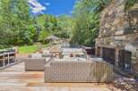 Experience luxurious outdoor living with this stunning deck featuring a cozy seating area, a refreshing pool, and a relaxing hot tub.