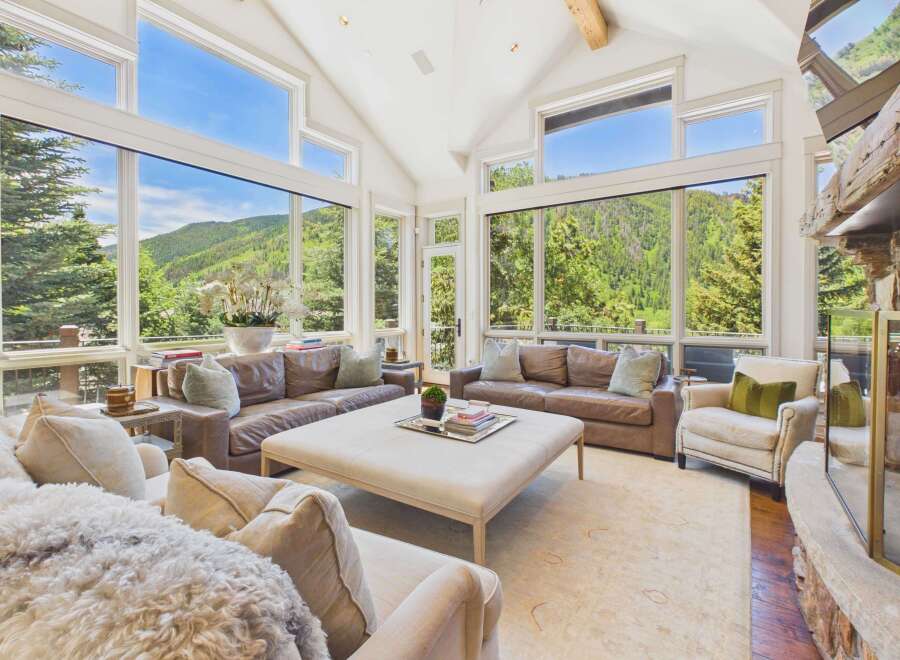 Experience breathtaking mountain views from this stunning living room, featuring expansive windows that flood the space with natural light.