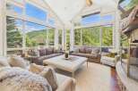 Experience breathtaking mountain views from this stunning living room, featuring expansive windows that flood the space with natural light.