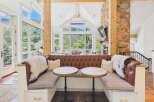 Experience luxurious mountain living in this stunning home featuring a cozy built-in banquette with plush leather upholstery and marble-topped bistro tables.