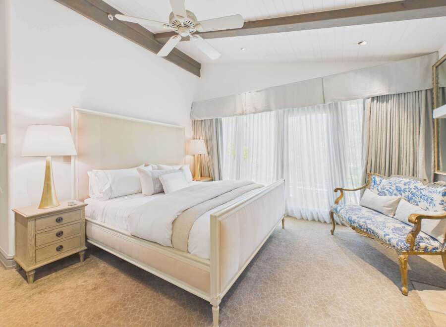Experience luxury in this master suite, featuring a plush king-sized bed with crisp white linens and elegant accent pillows.