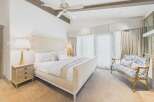 Experience luxury in this master suite, featuring a plush king-sized bed with crisp white linens and elegant accent pillows.