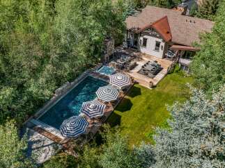 Experience luxurious outdoor living with this stunning property featuring a large swimming pool and an adjacent hot tub, perfect for relaxation and entertainment.