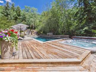 Escape to this luxurious backyard oasis featuring a sparkling swimming pool and a relaxing hot tub, perfect for unwinding.