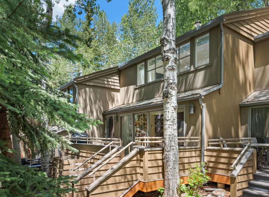 Nestled amongst mature trees, this property offers a serene retreat with its multi-level decks and natural wood siding.