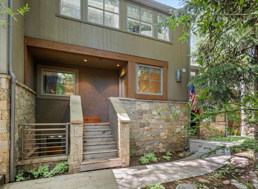 This charming property features a rustic stone exterior complemented by warm wooden accents and a welcoming entrance.