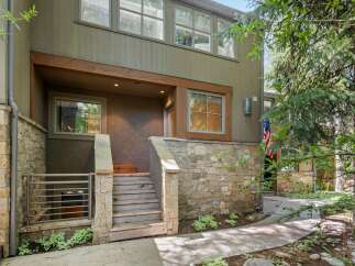 This charming property features a rustic stone exterior complemented by warm wooden accents and a welcoming entrance.