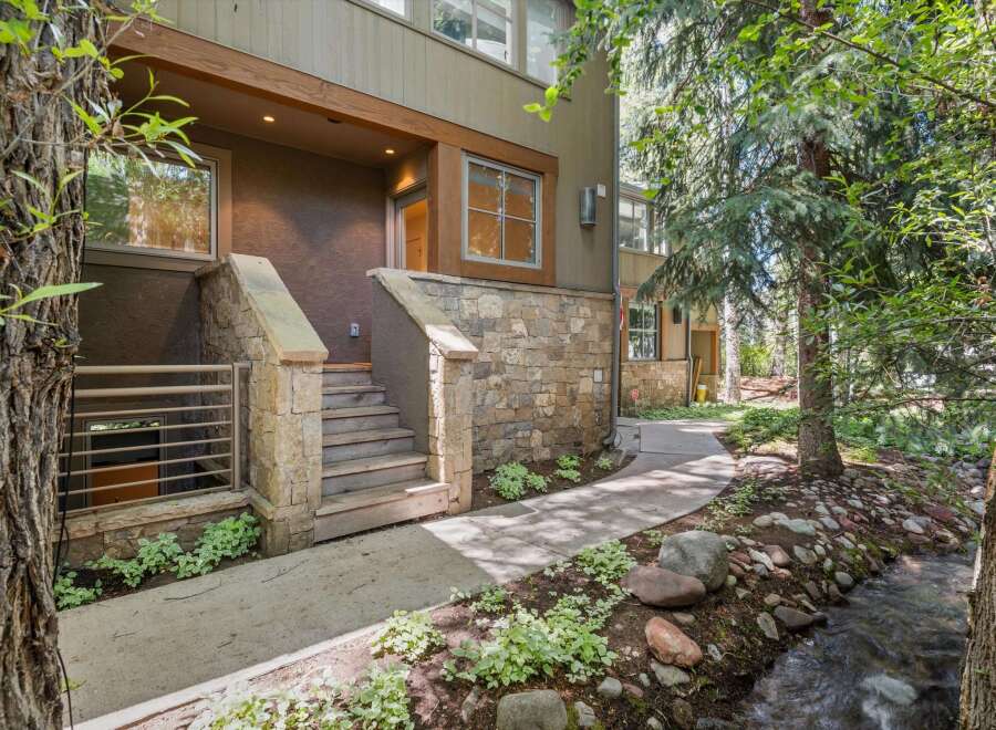 Nestled beside a serene creek and surrounded by lush trees, this property offers a unique blend of modern living and natural beauty.