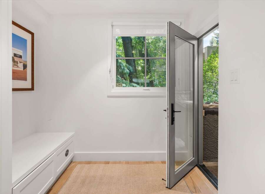 Step into this inviting entryway featuring a built-in white bench with ample storage, perfect for stowing away shoes and accessories.