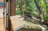 Experience serene living with this stunning property featuring a tranquil stream flowing through lush greenery right outside your door.