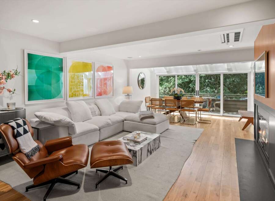 Experience modern living in this stunning open-concept living and dining area, bathed in natural light from expansive windows.