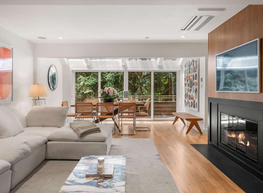 Experience modern living in this stunning open-concept living and dining area, bathed in natural light from expansive sliding glass doors.