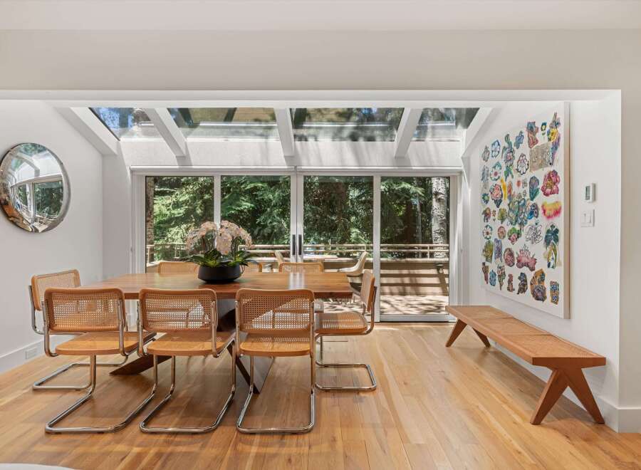This dining room boasts a stunning wooden dining table surrounded by elegant cane-backed chairs, perfect for intimate gatherings.