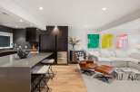 Experience modern living in this open-concept space, featuring a sleek kitchen with dark wood cabinetry and a large island perfect for entertaining.