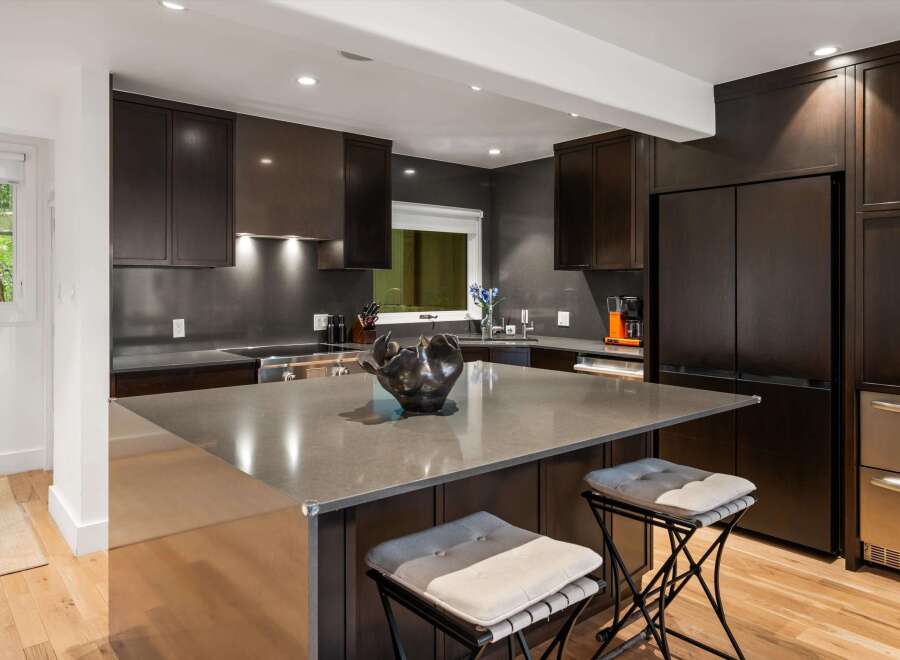 Experience luxury in this modern kitchen featuring dark wood cabinetry and sleek countertops.