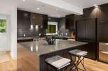 Experience luxury in this modern kitchen featuring dark wood cabinetry and sleek countertops.