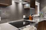 Experience culinary excellence in this modern kitchen, featuring a sleek induction cooktop integrated into a sophisticated quartz countertop.