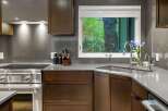 This modern kitchen boasts sleek dark wood cabinetry and a sophisticated gray countertop.