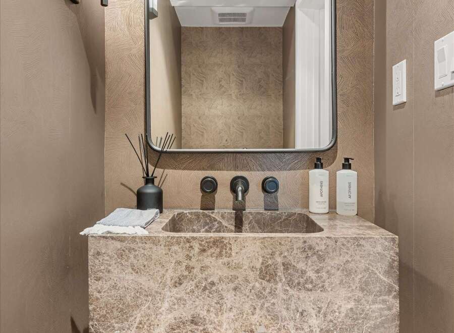 Elevate your bathroom with this stunning vanity featuring a unique marble countertop and a modern wall-mounted faucet.