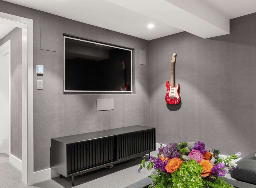 Experience modern comfort in this stylish living space, featuring a sleek entertainment center and a large flat-screen TV perfect for movie nights.