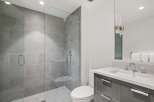 Experience modern luxury in this stunning bathroom featuring a spacious glass-enclosed shower with sleek gray tilework.
