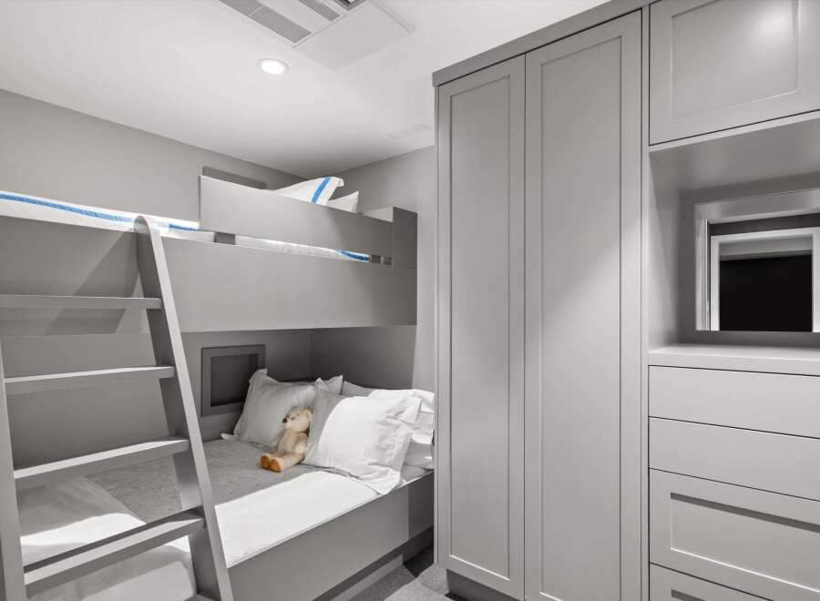 This modern bedroom features a space-saving bunk bed with a ladder, perfect for children's rooms or guest accommodations.