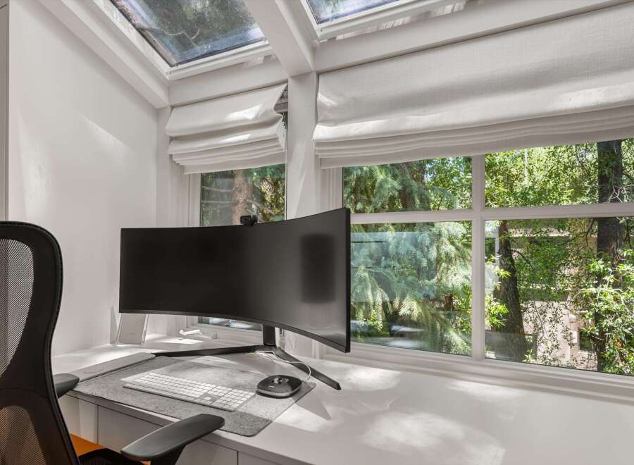 This home office boasts a sleek, curved monitor and a comfortable mesh chair, perfect for productivity.