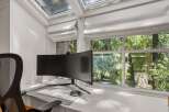 This home office boasts a sleek, curved monitor and a comfortable mesh chair, perfect for productivity.
