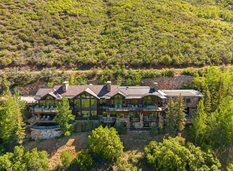 Experience luxury mountain living in this stunning estate, nestled against a verdant hillside.