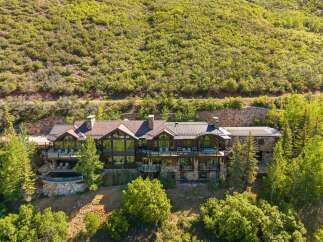 Experience luxury mountain living in this stunning estate, nestled against a verdant hillside.