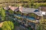 Experience luxury mountain living in this stunning estate, featuring expansive decks with breathtaking views and elegant outdoor seating areas perfect for entertaining.