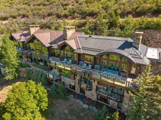 Experience luxury mountain living in this stunning estate, featuring expansive decks with breathtaking views and elegant outdoor seating areas perfect for entertaining.