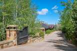 Discover this stunning mountain estate, accessed via a grand stone gate and a winding driveway lined with mature trees.