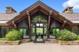 Experience breathtaking mountain views from this stunning entryway, featuring expansive glass walls and a grand chandelier.