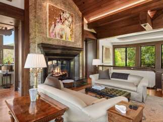 Experience luxury living in this stunning living room, featuring a grand marble fireplace and a captivating abstract artwork.